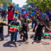 A group of Youths with holding the national flag with some kneeling down in Surrender and some raising arms crossed as a sign of peace amidst the June protest against the finance bill 2024